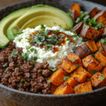 Ground beef sweet potato cottage cheese bowl served with avocado and hot honey